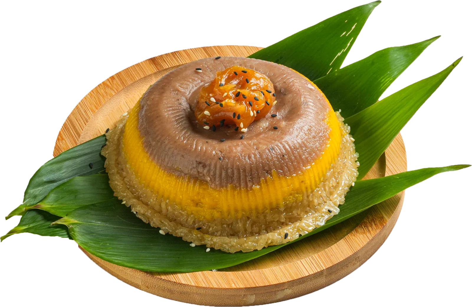 Steamed glutinous rice cake layered with yam and sweet potato, topped with preserved fruit and sesame, on a bamboo plate with pandan leaves