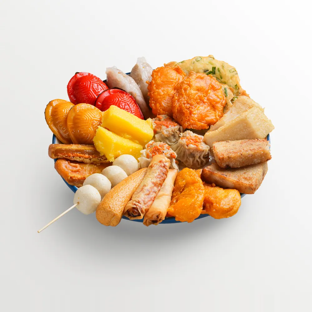 White background food photography of a mixed steamed and fried platter — yong tau foo, siu mai, fish balls, spring rolls, yam cake and prawn fritters